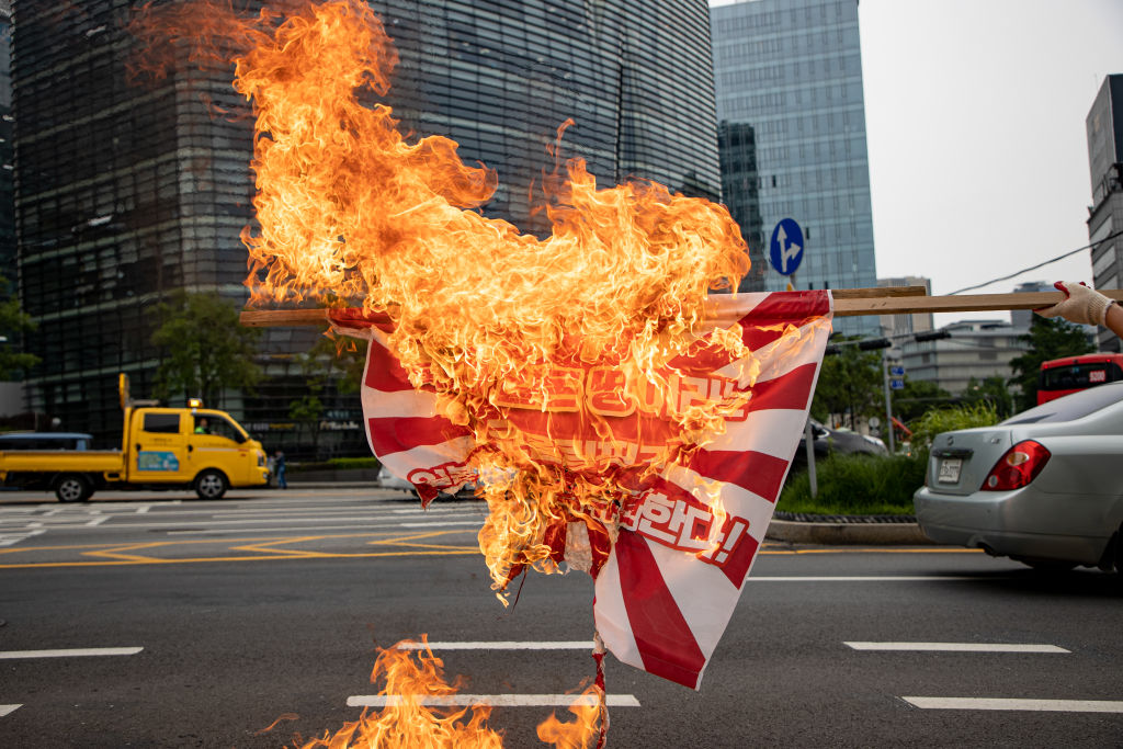 Members of the Korean University Student Progressive Association burn a Japanese war flag across from the Japanese Embassy on June 1, 2020 in Seoul, South Korea. (Chris Jung/Nur Photo via Getty Images)