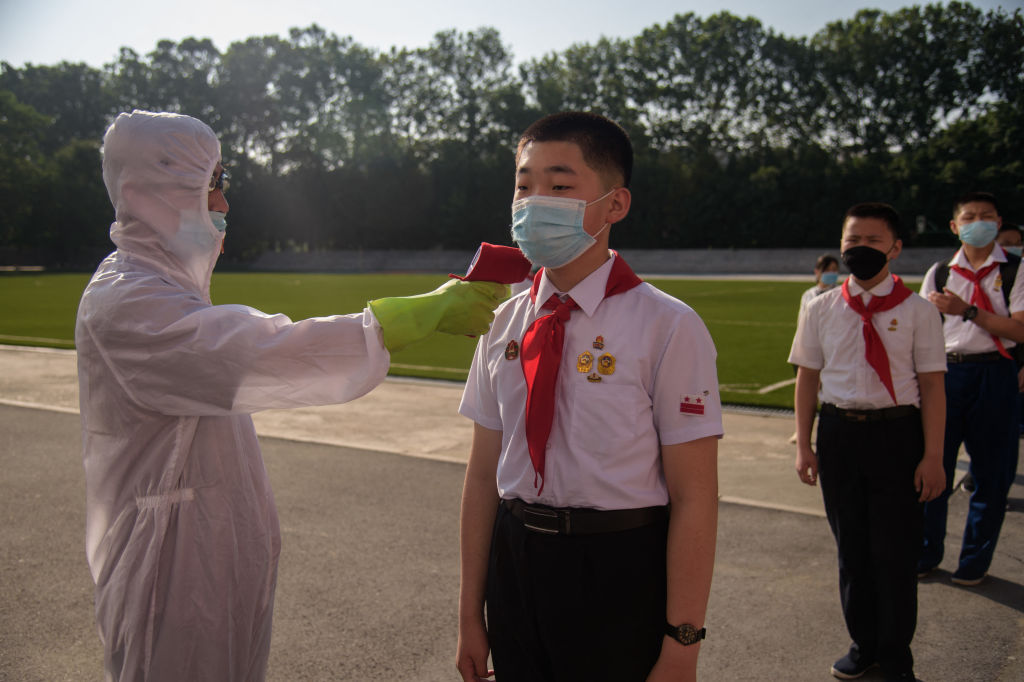 A pupil has his temperature taken as part of anti COVID-19 procedures before entering the Pyongyang Secondary School No. 1 in Pyongyang on June 22, 2021. (KIM WON JIN/AFP via Getty Images)