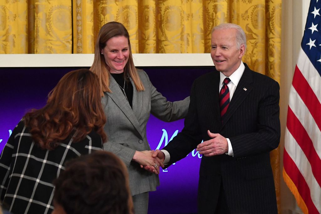US President Joe Biden greets Cindy Parlow Cone, president of the US Soccer Federation, as he arrives for the Equal Pay Day event to celebrate Womens History Month in the East Room of the White House in Washington, DC, March 15, 2022. (NICHOLAS KAMM/AFP via Getty Images)