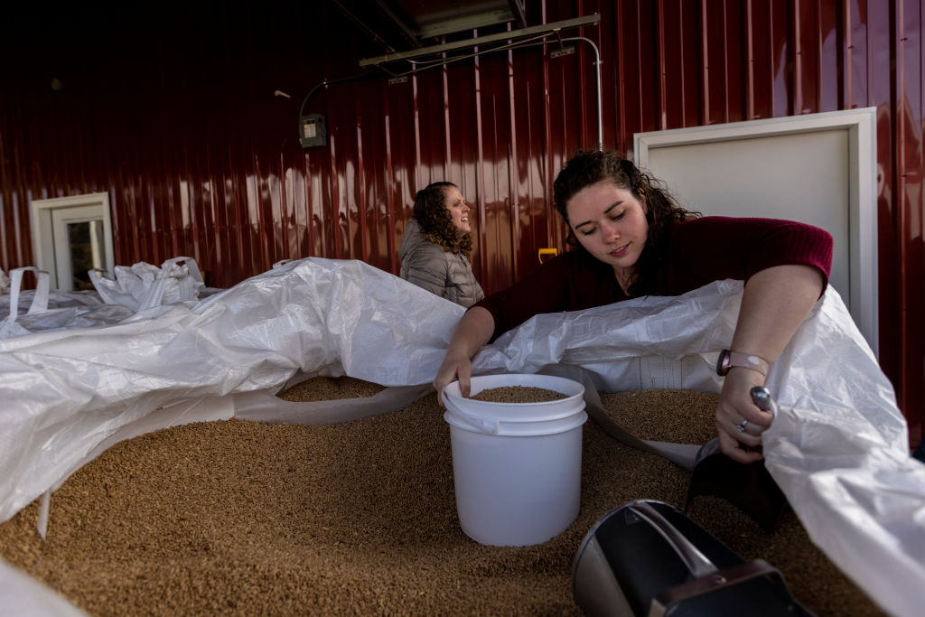 With prices rising, Allie Eidam (R) stocks up on wheat at a grain sale on March 31, 2022 in Sugar City, Idaho. (Natalie Behring/Getty Images)