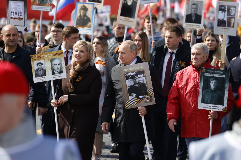 Russian President Vladimir Putin (C) holds a portrait of his father during the Immortal Regiment, a rally where people carrying portraits of their relatives-veterans of WWII, after the Victory Day Parade at Red Square, May 9, 2022, in Moscow, Russia. (Sefa Karacan-Anadolu Agency)