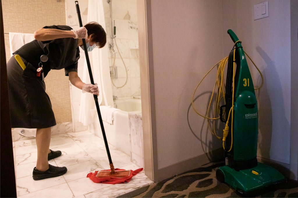 Nu Vong, a housekeeper for the past 32 years, works to clean a room on the 32nd floor of the Westin St. Francis hotel in San Francisco, Calif. Monday, February 1, 2021. (Jessica Christian/The San Francisco Chronicle via Getty Images)