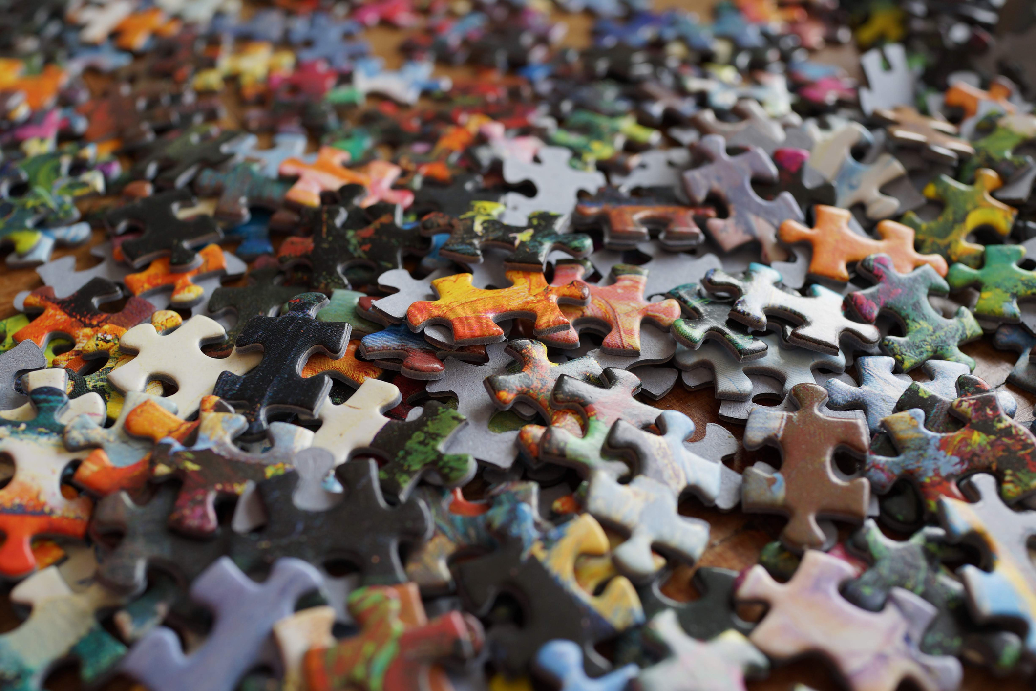 High Angle View Of Multi Colored Puzzle Pieces On Table