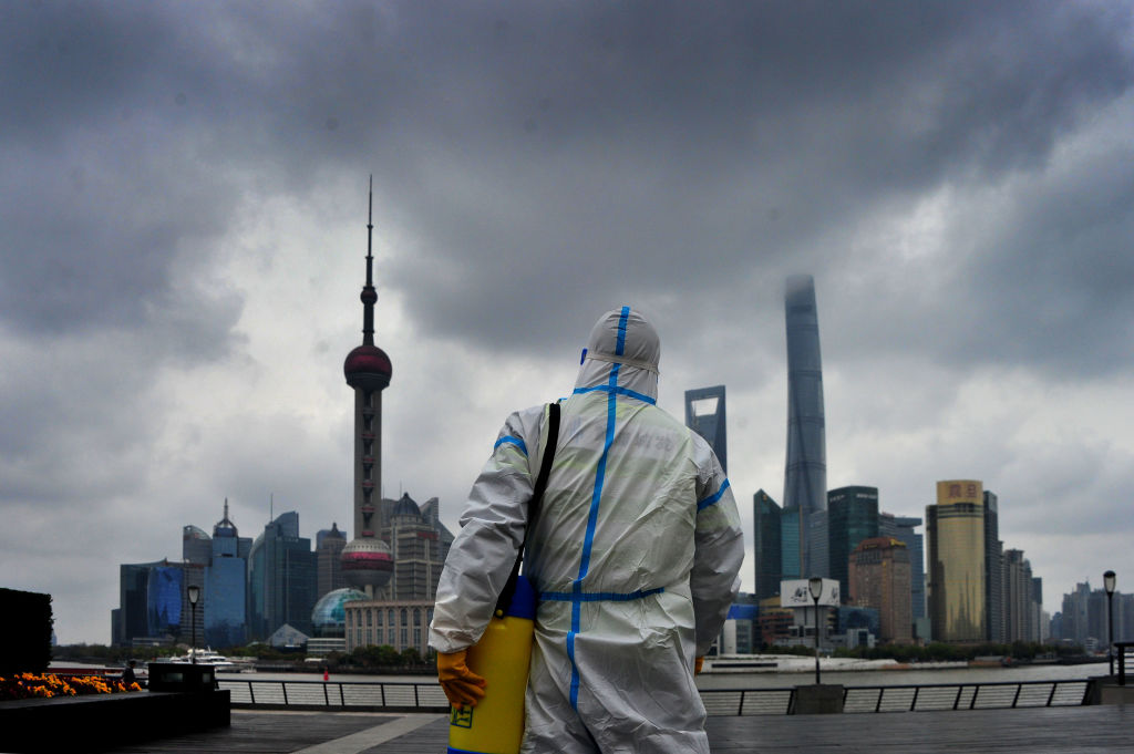 A sanitation worker wearing personal protective equipment conducts disinfection work at the Bund on March 31, 2022 in Shanghai, China. (Photo by Yang Jianzheng/VCG via Getty Images)