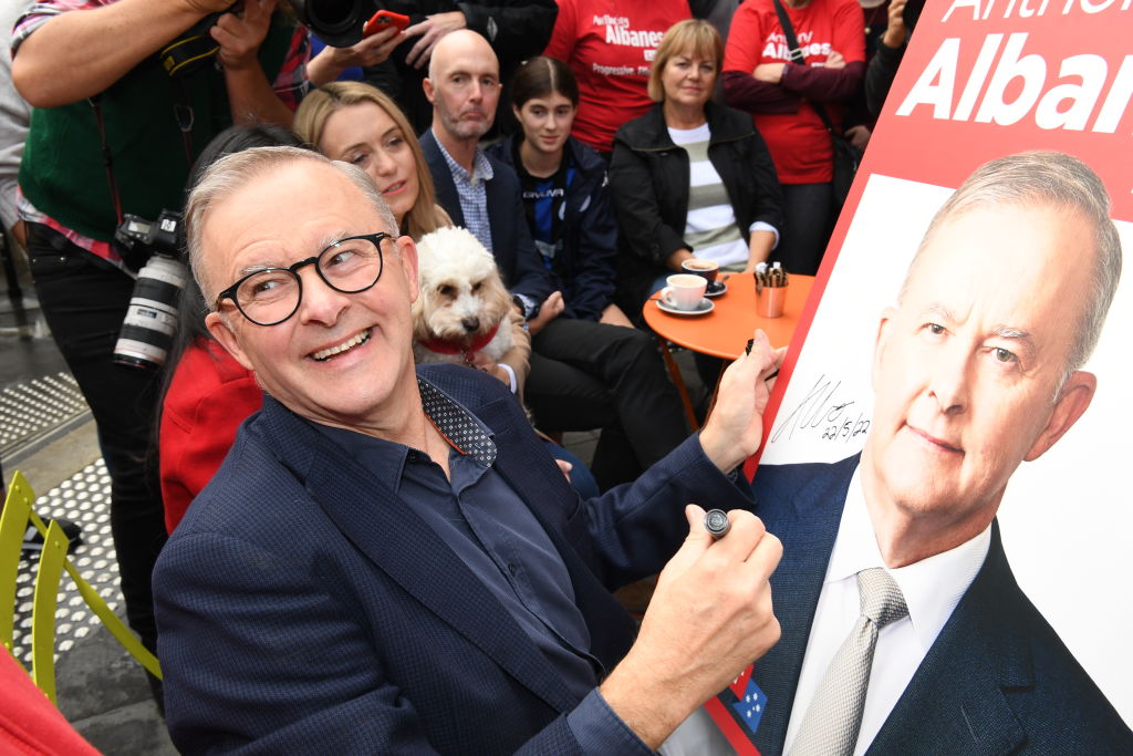 Prime minister-elect Anthony Albanese signs a poster for a young boy as he shares a coffee near his home on May 22, 2022 in Sydney, Australia. (James D. Morgan/Getty Images)