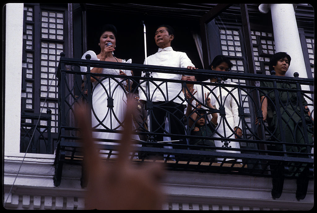 Late Philippine dictator Ferdinand Marcos stands by as his wife Imelda sings to supporters from a balcony of the Malacanang Palace in Manila, February 25, 1986. Their son, Bongbong Marcos, is at far right. This was the last public appearance by Marcos and his family before exile. (Alex Bowie/Getty Images)