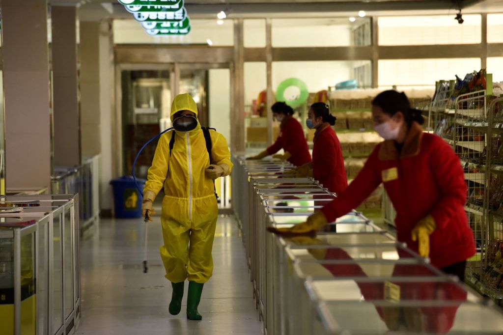 Employees spray disinfectant and wipe surfaces at a Pyongyang department store on March 18, 2022. (Kim Won Jin—AFP/Getty Images)