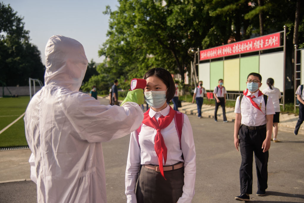 A pupil has her temperature taken as part of anti-COVID-19 procedures before entering a school in Pyongyang on June 22, 2021. (Kim Won Jin—AFP/Getty Images)