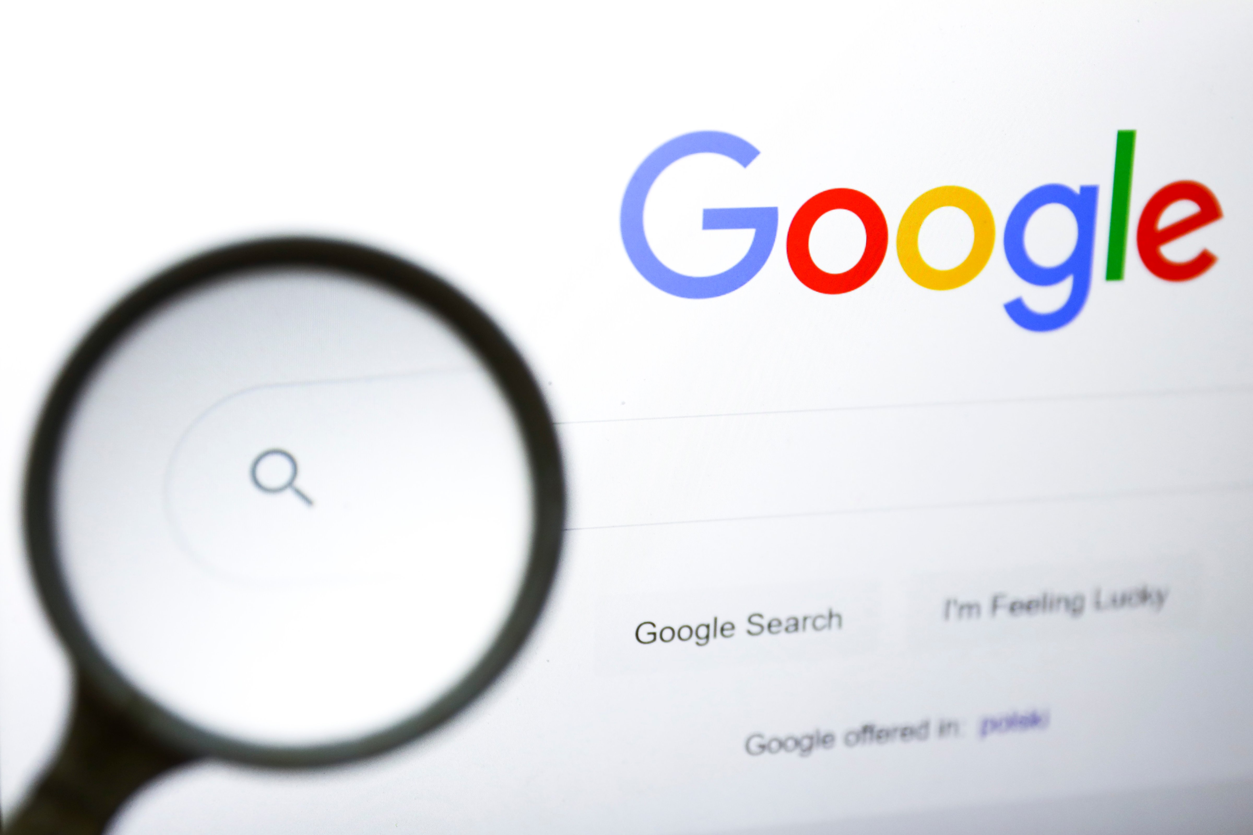 A magnifying glass is photographed with Google's logo displayed on a laptop screen. (Beata Zawrzel—NurPhoto/Getty Images)