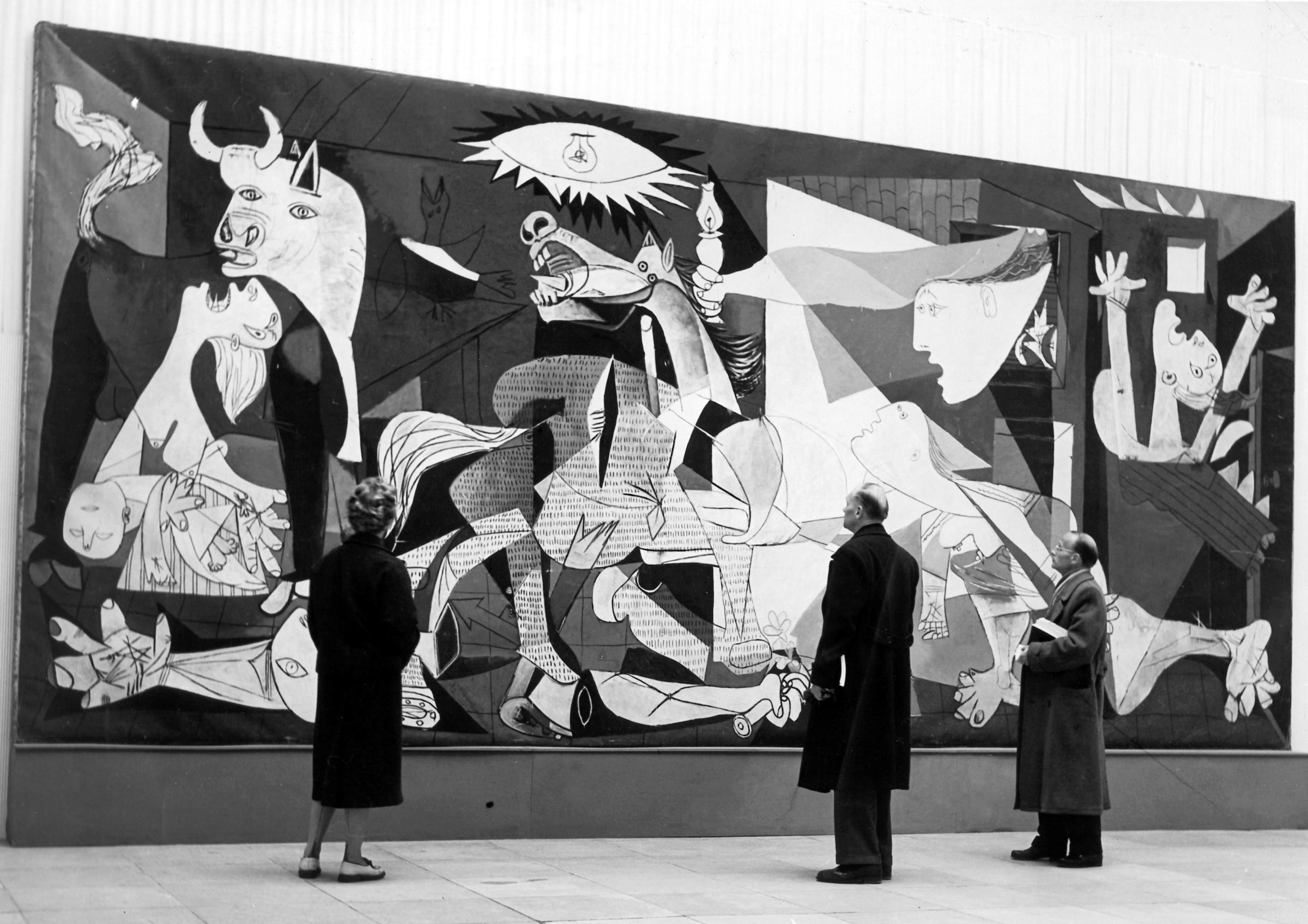Visitors to the Picasso exhibition in Munich, Germany, in October 1955 look at the famous painting 'La Guernica' by Pablo Picasso.