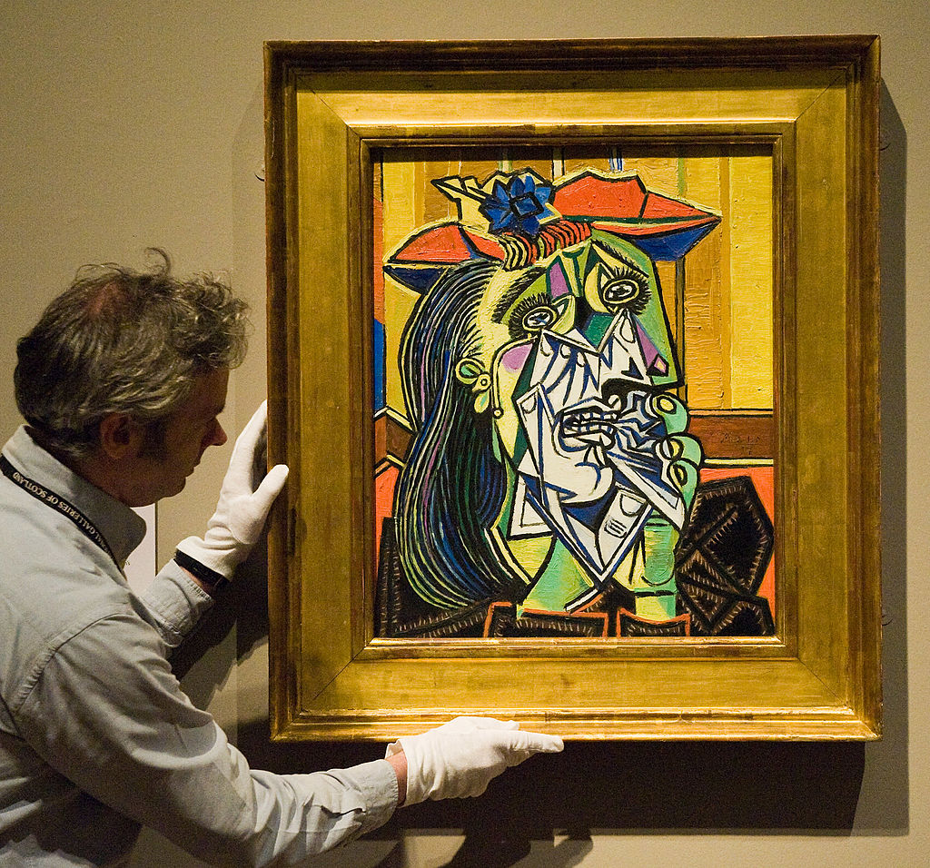 A National Gallery employee positions Picasso's 'The Weeping Woman' at the National Gallery 'Goya to Picasso' Exhibition on July 17, 2009 in Edinburgh, Scotland