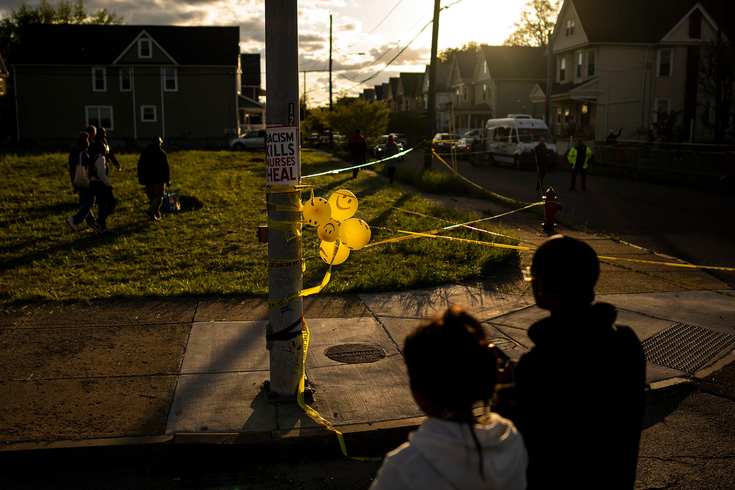 People walking near the intersection of Jefferson Avenue and Riley Street attend a vigil across the street from Tops Friendly Market in Buffalo, NY on May 17, 2022. The Supermarket was the site of a fatal shooting of 10 people at a grocery store in a historically Black neighborhood of Buffalo by a young white gunman is being investigated as a hate crime and an act of racially motivated violent extremism, according to federal officials. (Kent Nishimura—Los Angeles Times/Getty Images)
