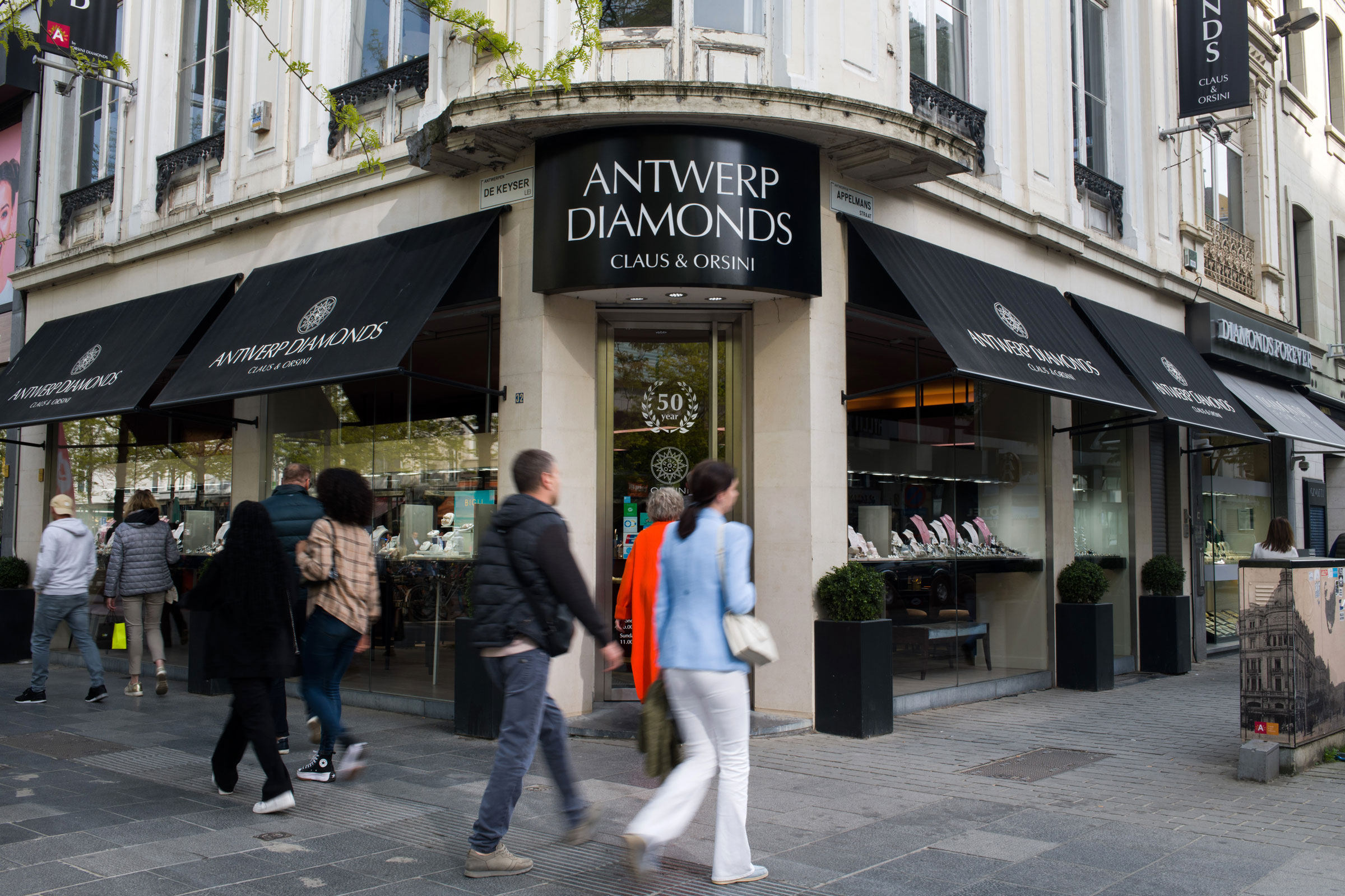 Pedestrians pass window shoppers browsing the Orsini Diamonds store in the Diamond Quarter of Antwerp, Belgium, on April 28. (Nathan Laine—Bloomberg/Getty Images)