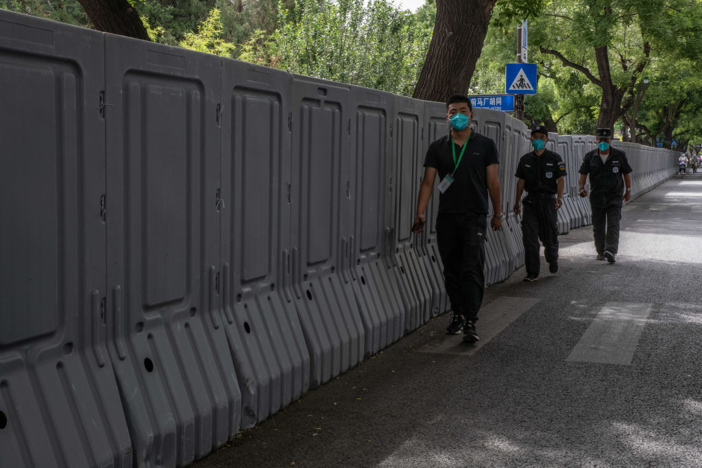 Security guards walk past barriers surrounding a neighborhood placed under lockdown due to COVID-19 in Beijing, on May 31, 2022. (Bloomberg/Getty Images)