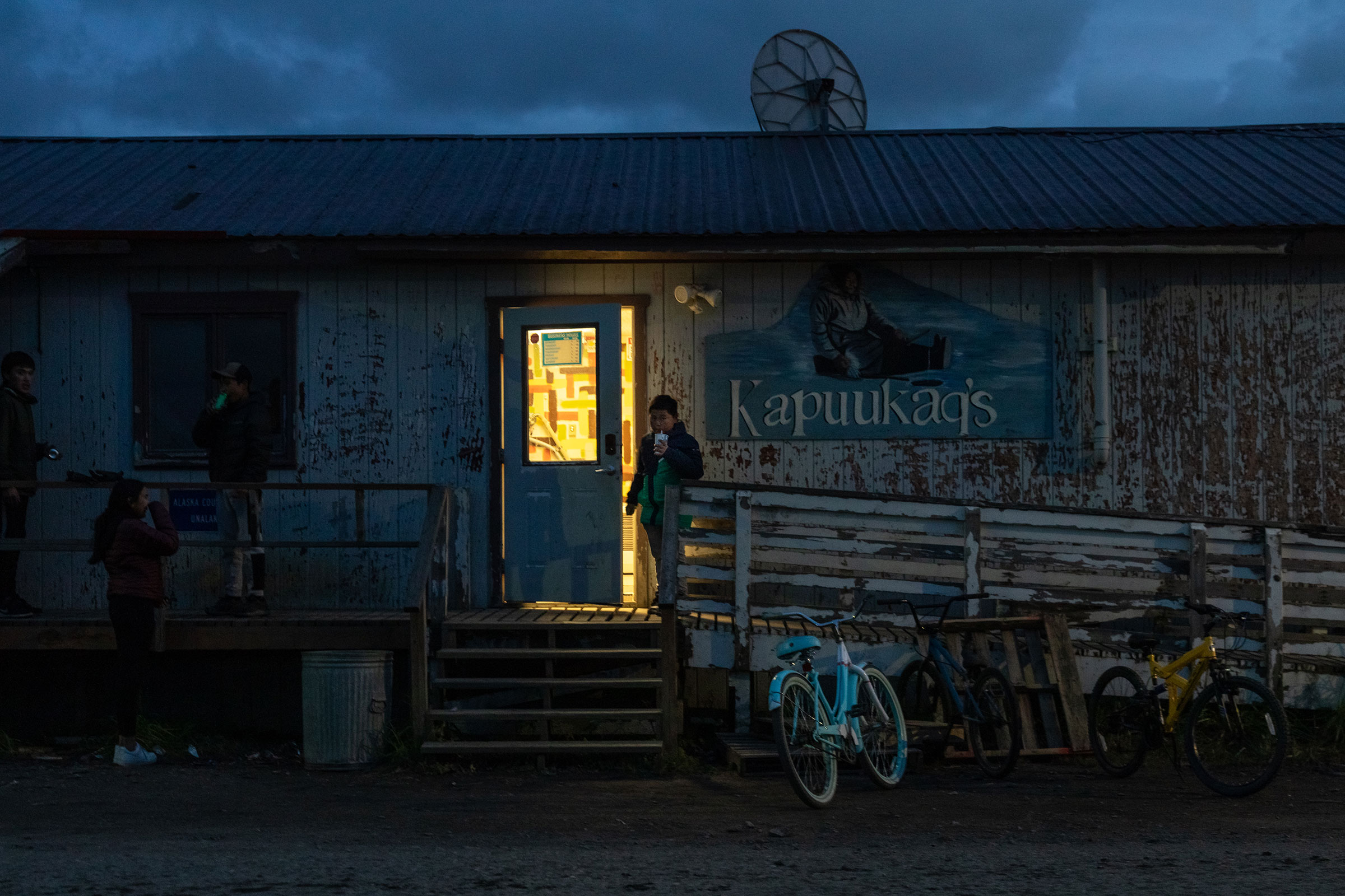 As a group of his friends wait outside, a boy exits a convenience store in Unalakleet, Alaska. (Acacia Johnson for TIME)