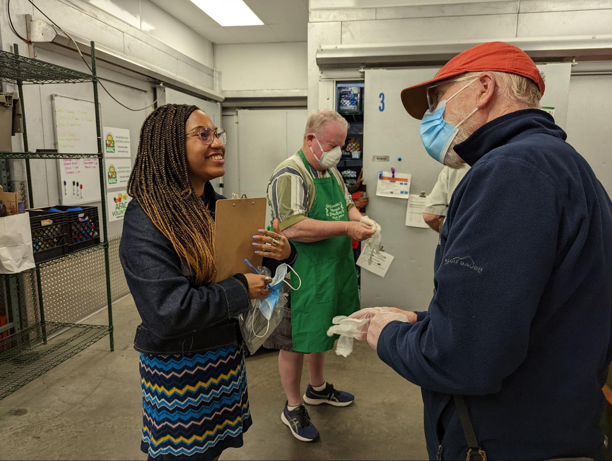 Chabeli Wells (left), volunteer coordinator at the Arlington Food Assistance Center, greets volunteers as they arrive. (Jeremiah Huston)