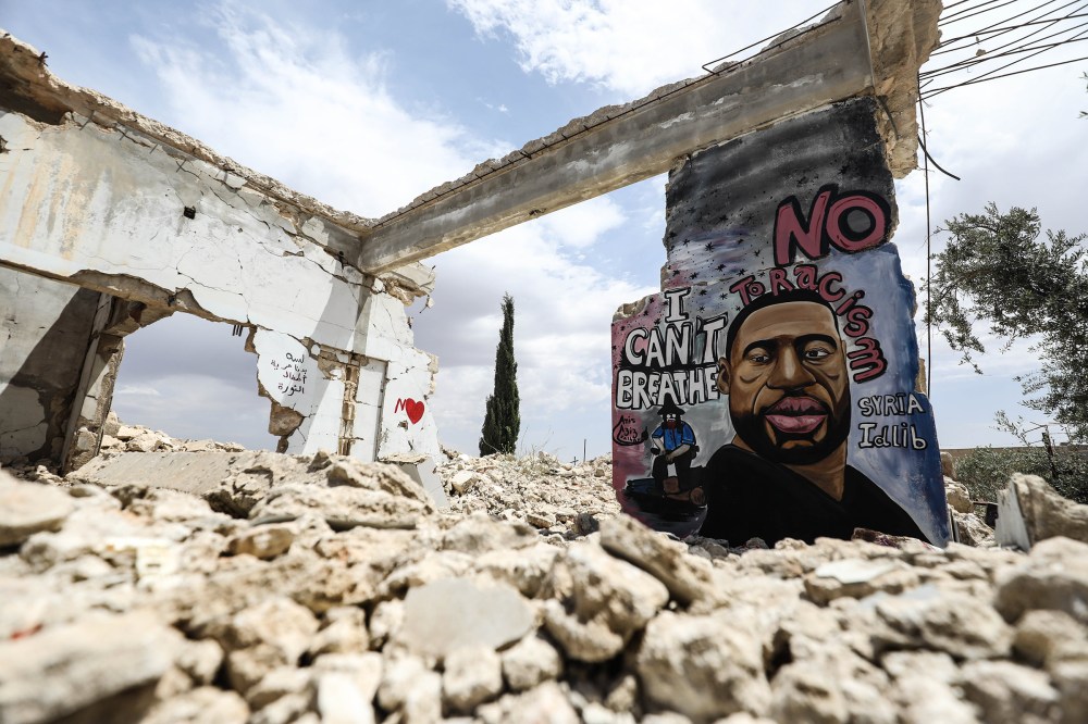 A mural depicting of George Floyd, an unarmed black man who died after being pinned down by a white police officer in Minneapolis, is seen painted on a wall of house ruins by a 36-year old graffiti artist Aziz Asmar in Binnish district in Idlib province, Syria on June 02, 2020.