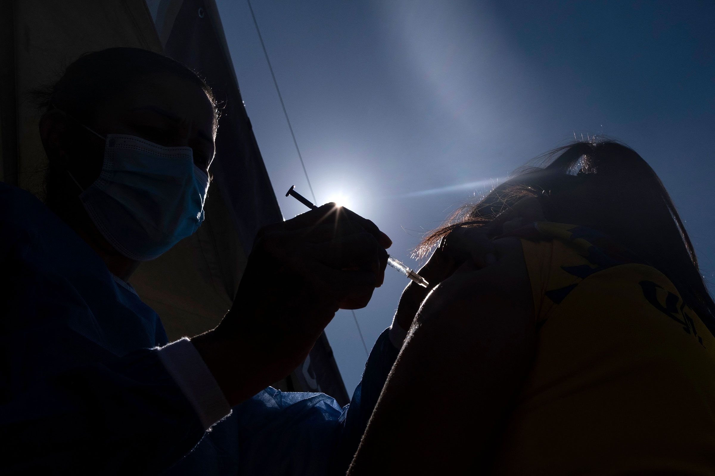 An asylum seeker camping on the border with the U.S. in Tijuana, Mexico, is vaccinated against COVID-19 on Aug. 3 (Guillermo Arias—AFP/Getty Images)