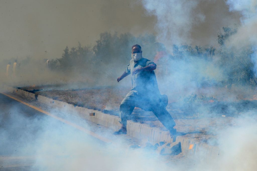 A supporter of Pakistan's former prime minister Imran Khan amid tear gas fired by police during a protest rally in Swabi on May 25. (Abdul Majeed—AFP/Getty Images)
