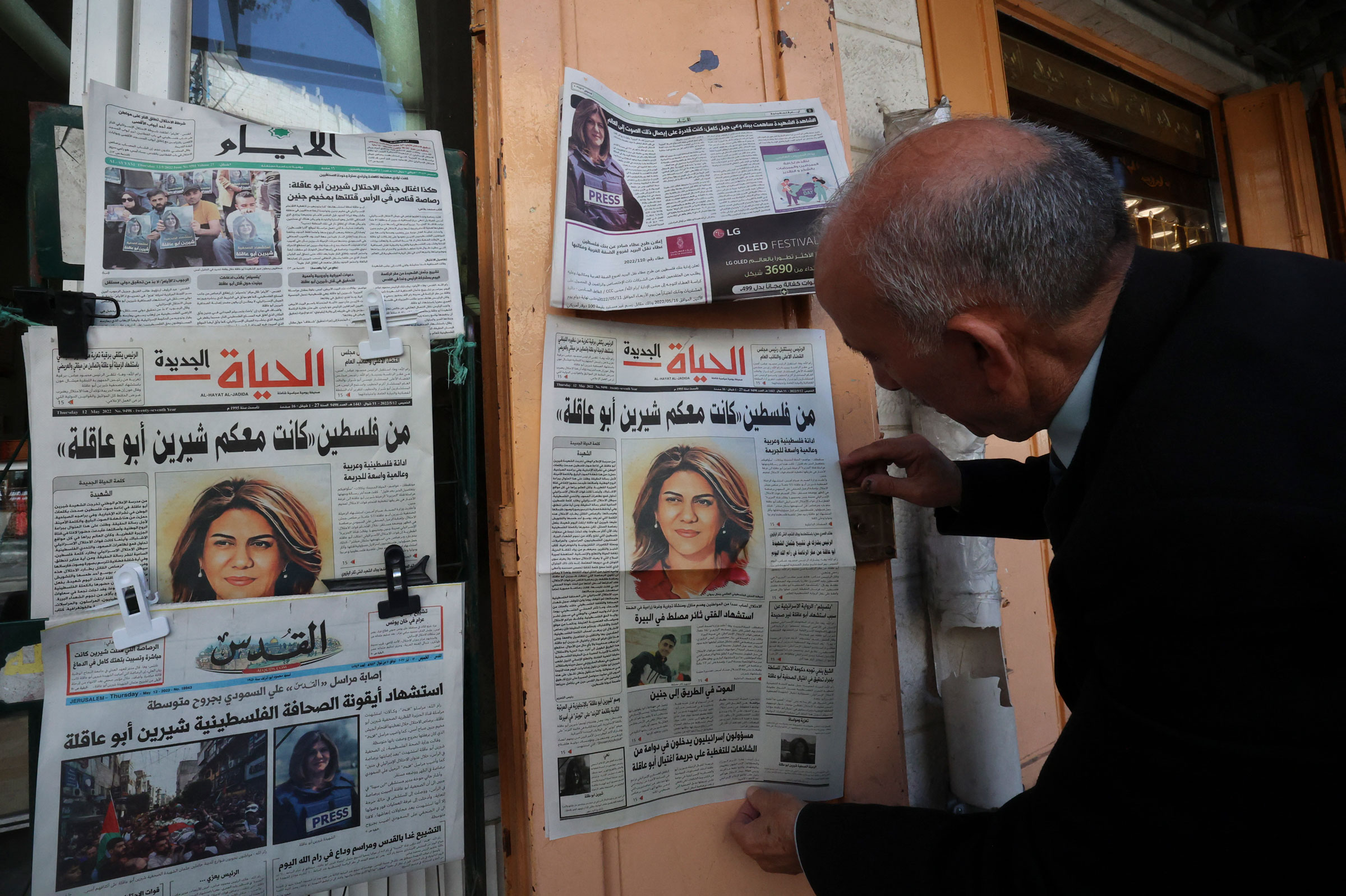 A Palestinian man looks at the front pages of local newspapers reporting on the death of veteran Al-Jazeera journalist Shireen Abu Akleh