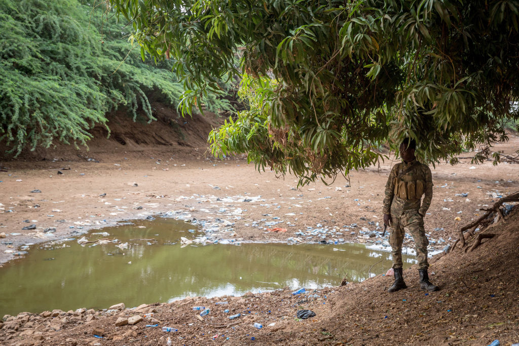 A soldier stands in front of the dried up Jubba river in Dollow, Jubaland, Somalia, on the border with Ethiopia, on April 12, 2022. (Sally Hayden—SOPA Images/LightRocket/Getty Images)