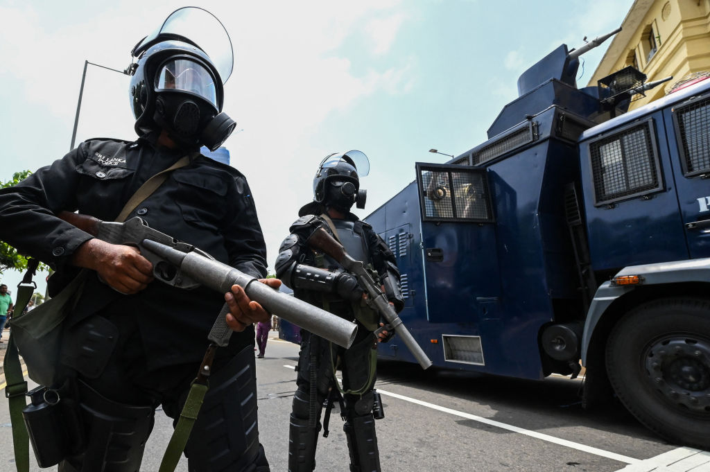 Police personnel stand guard outside the President's office as his supporters and anti-government protesters clash in Colombo on May 9, 2022. (Ishara S. Kodikara—AFP/Getty Images)