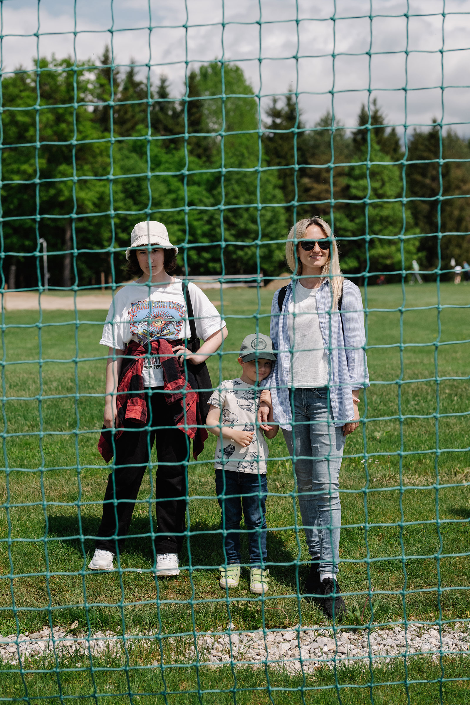 Kseniia Nikitina, from the Ukrainian city of Zhytomyr, watches the team train, along with her 12-year-old daughter Alisa, and 4-year-old son Martin (Ciril Jazbec for TIME)