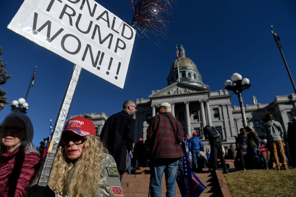 Hetti Hennessey sits on the west steps at the Colorado State Capitol during a pro-Donald Trump rally on Jan. 6, 2021. More than 1,000 people gathered to contest Joe Biden's victory in the presidential election. (Aaron Ontiveroz—MediaNews Group/The Denver Post/Getty Images)