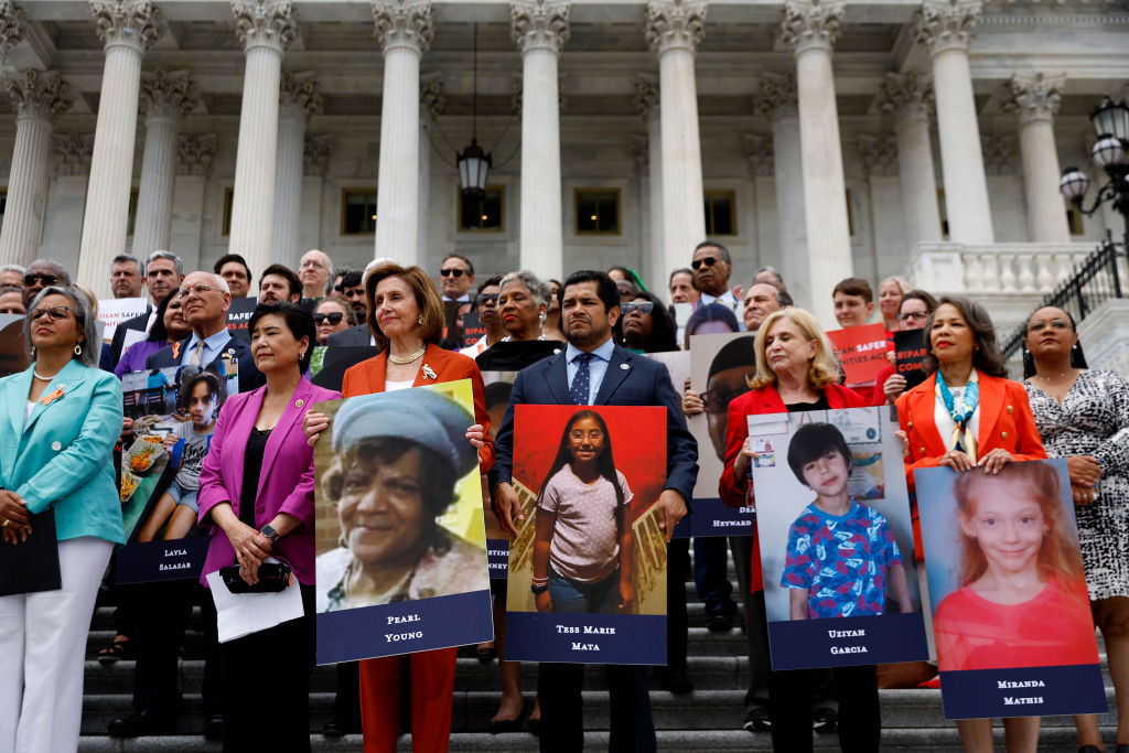 House Speaker Nancy Pelosi stands with fellow Democrats holding photographs of the victims of the mass shootings in Buffalo, New York and Uvalde, Texas, before passing the Bipartisan Safer Communities Act in front of the House of Representatives on June 24, 2022 in Washington, DC. (Chip Somodevilla/Getty Images)