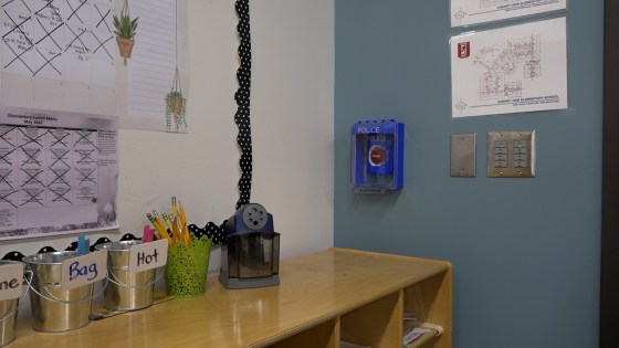 Police button behind case in classroom