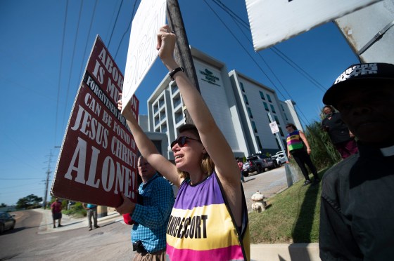 Anti-abortion protestors surround Ren Allen, center, an escort for the Jackson Women's Health Organization in Jackson, Miss., after the U.S. Supreme Court overturned Roe v. Wade on June 24, 2022.