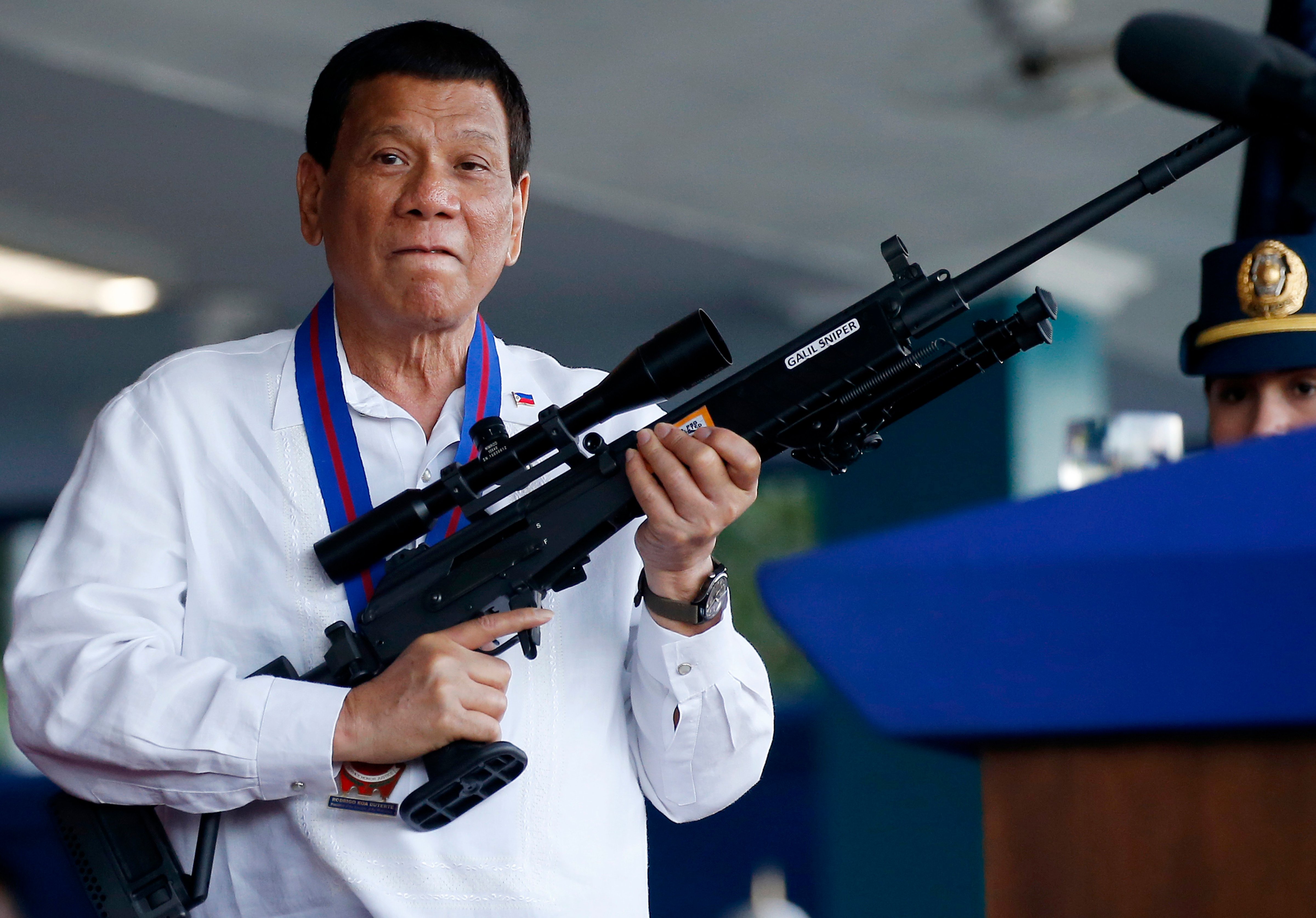 Philippine President Rodrigo Duterte jokes to photographers as he holds an Israeli-made Galil rifle at Camp Crame in suburban Quezon city northeast of Manila, Philippines on April 19, 2018. (Bullit Marquez/AP)