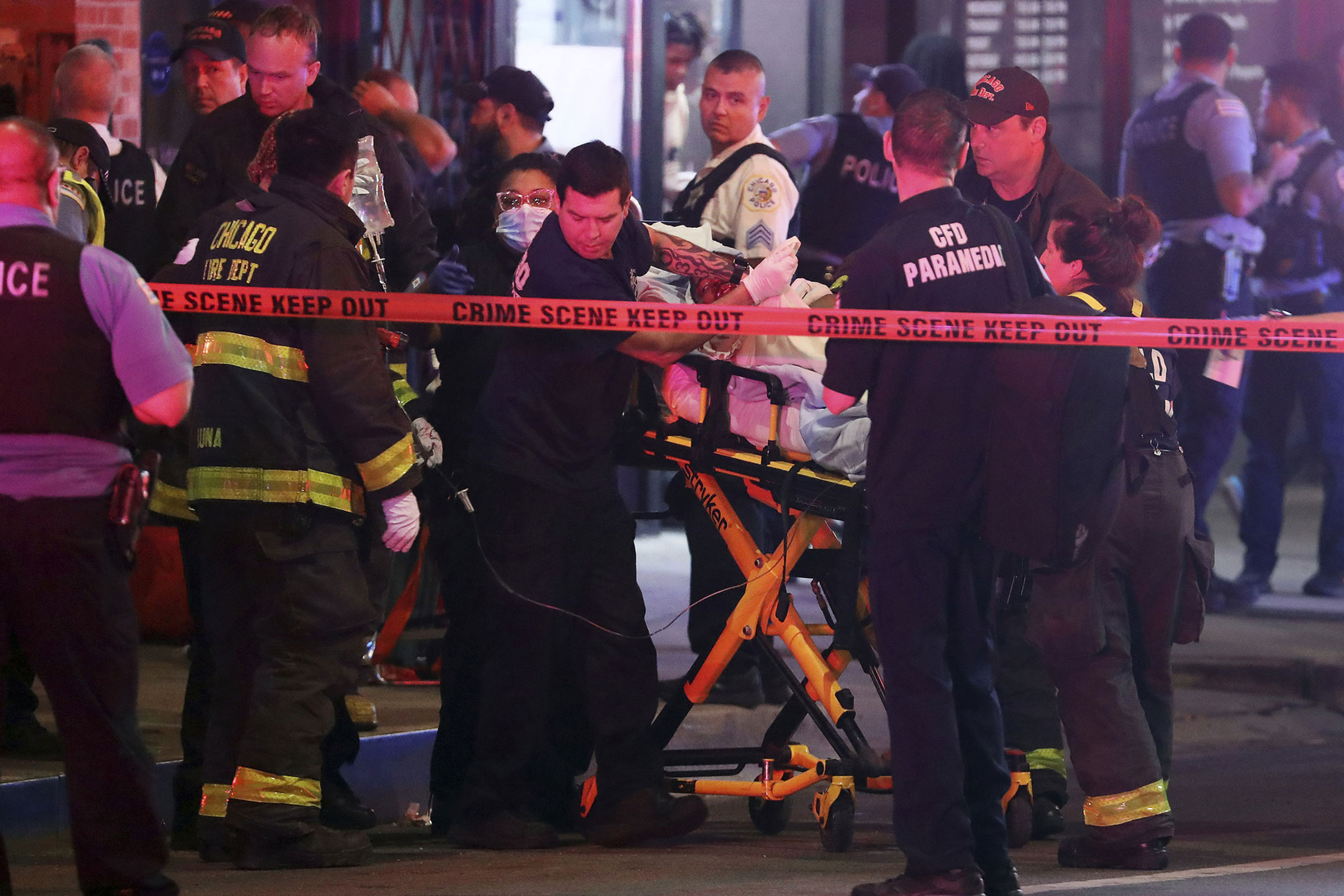 First responders move a shooting victim to an ambulance in downtown Chicago, May 14, 2022. A teenage boy was shot and killed near the sculpture Cloud Gate in Millennium Park. (Terrence Antonio James—Chicago Tribune/Getty Images)