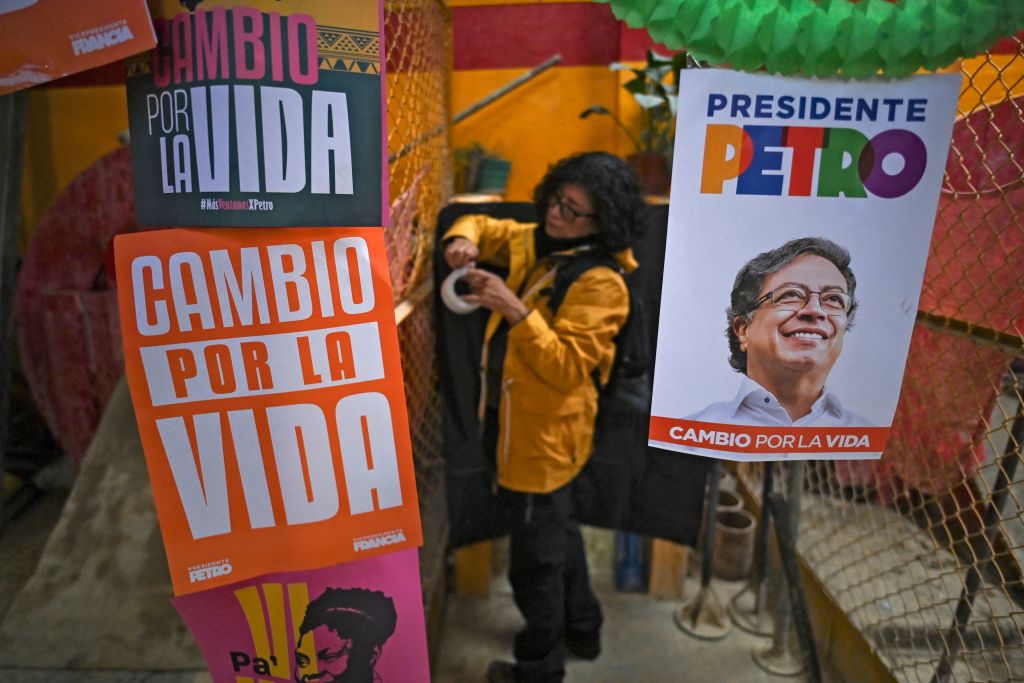 A supporter of Colombian left-wing presidential candidate Gustavo Petro pastes a banner before a rally at the Fontibon neighborhood in Bogota on June 12, 2022. (Juan Barreto—AFP/ Getty Images)
