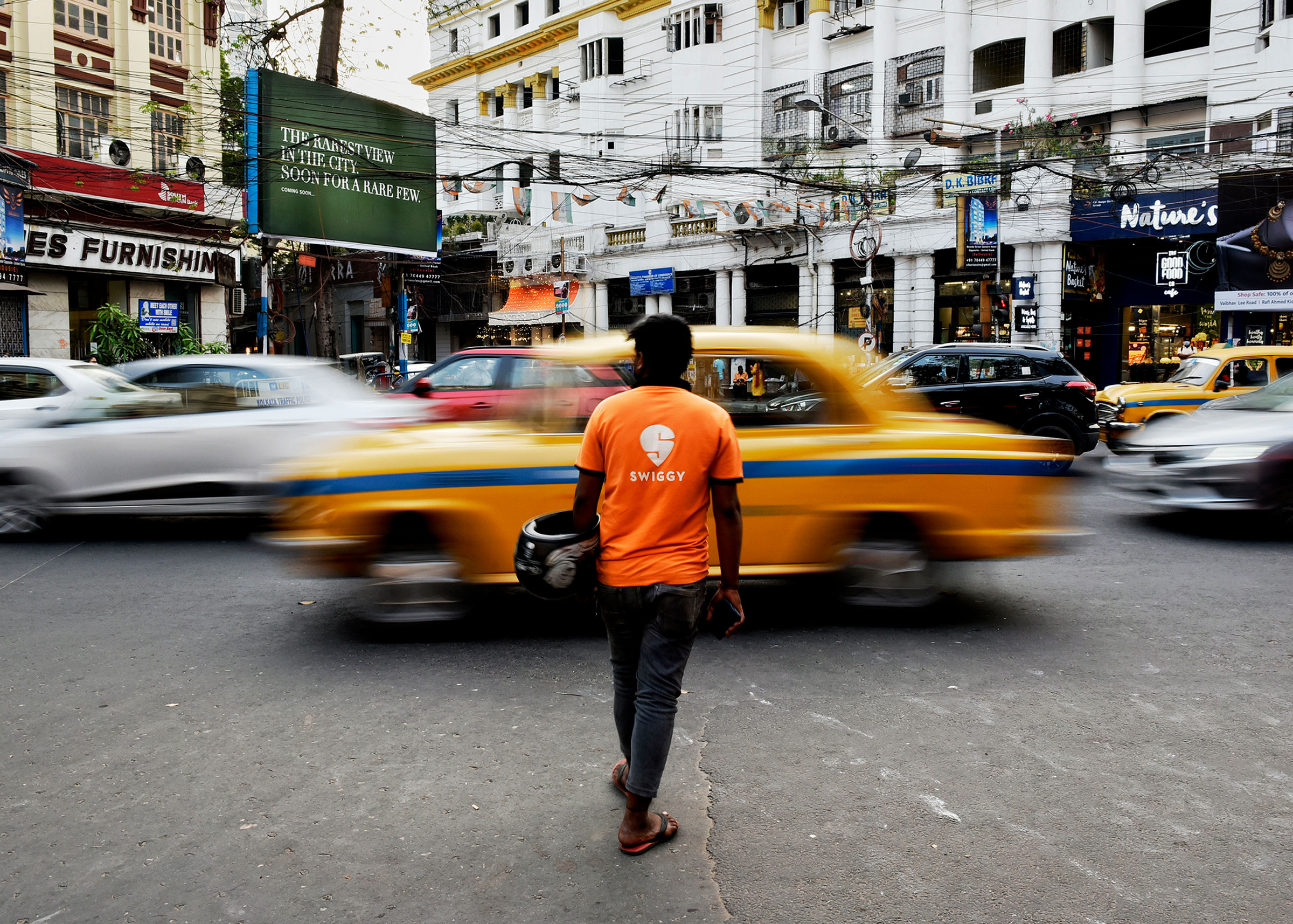 A Swiggy delivery worker crosses a road in Kolkata, India, March 22, 2022. (Indranil Aditya—NurPhoto/Getty Images)