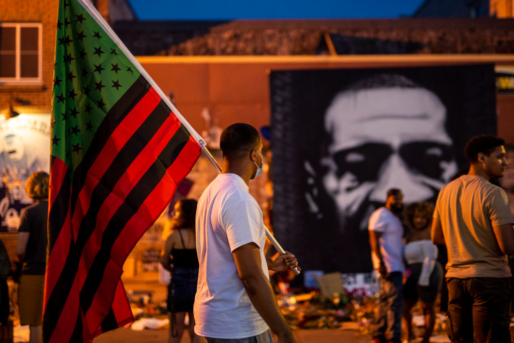 A man carries a Black Liberation flag through a Juneteenth celebration at the memorial for George Floyd outside Cup Foods on June 19, 2020, in Minneapolis. (Stephen Maturen—Getty Images)