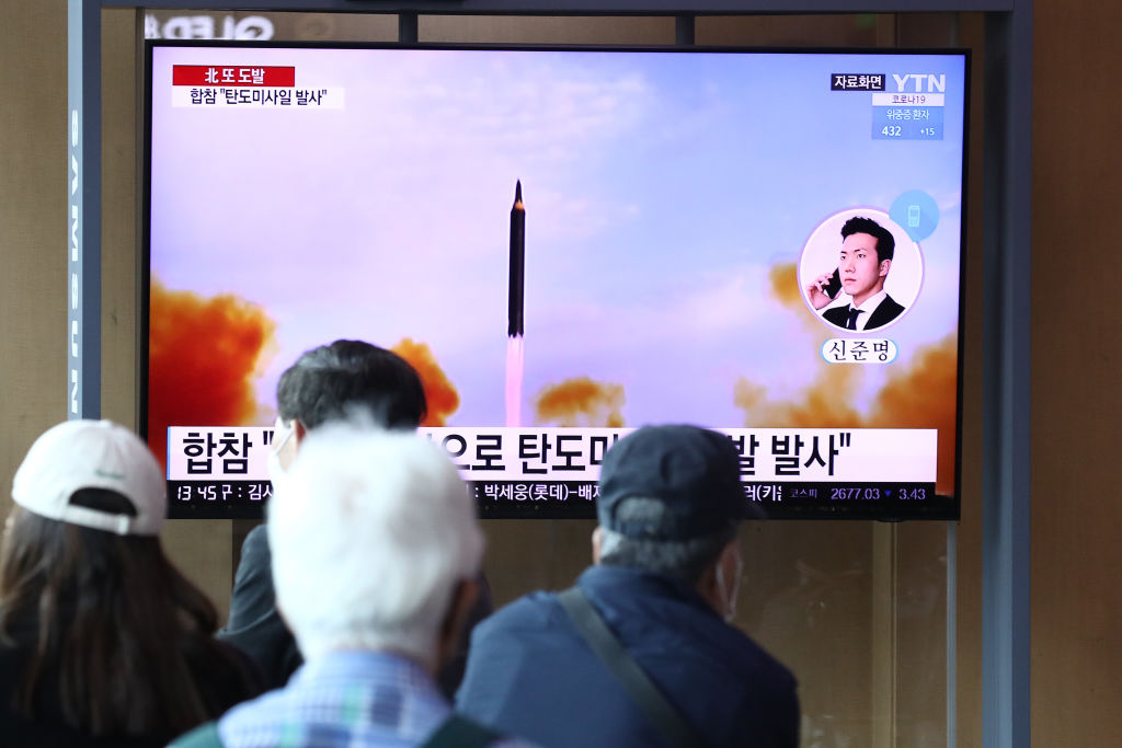 Люди на сеульском железнодорожном вокзале смотрят телевизионную трансляцию, показывающую файл с изображением запуска северокорейской ракеты 4 мая 2022 года в Южной Корее. (Чунг Сон Джун/Getty Images)