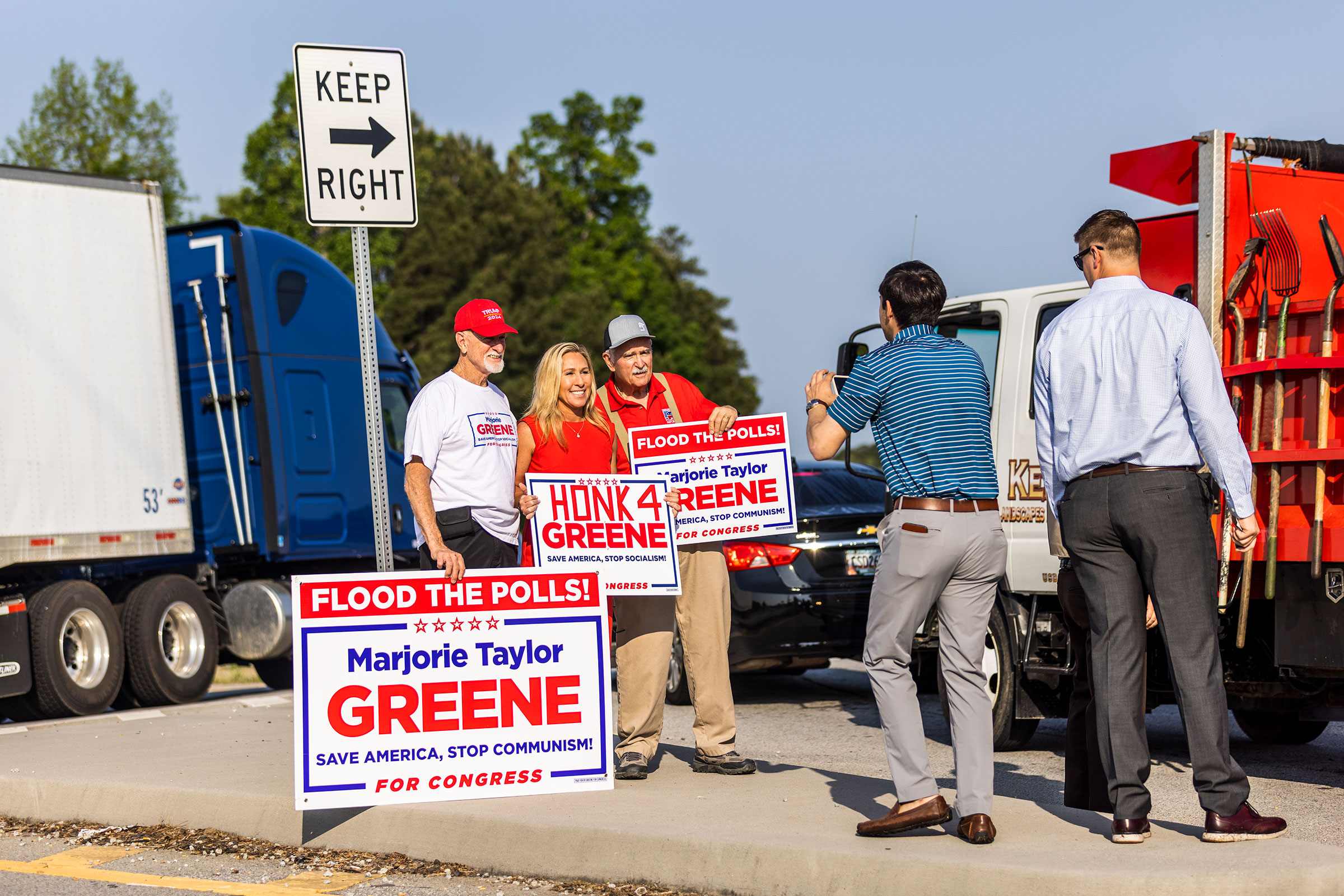 Greene waves signs with supporters outside a voting center in Dallas, Ga. (Andrew Hetherington for TIME)