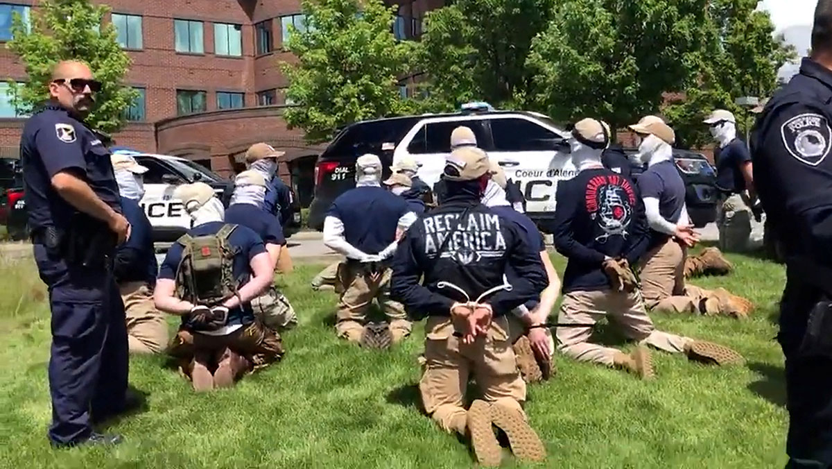 Police officers stand near a group of men, who police say are among 31 arrested for conspiracy to riot and are affiliated with the white nationalist group Patriot Front, after they were found in the rear of a U-Haul van in the vicinity of a North Idaho Pride Alliance LGBTQ+ event in Coeur d'Alene, Idaho, U.S. June 11, 2022. (North Country Off Grid/Youtube/Reuters)