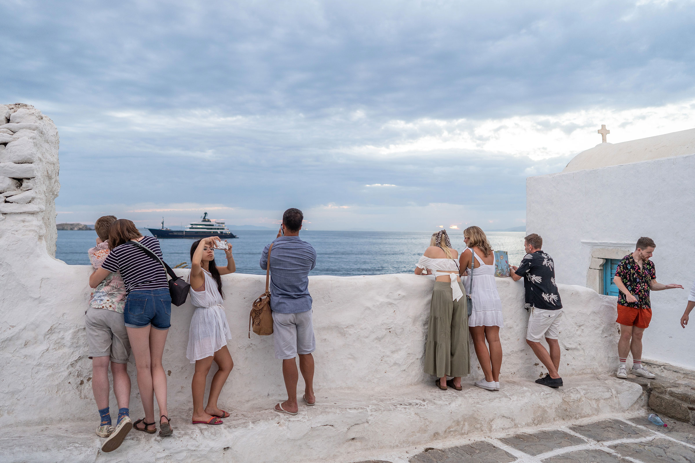 Visitors take photos of the sunset in Chora, Mykonos, Greece, on June 11, 2022. (Nick Paleologos—Bloomberg/Getty Images)