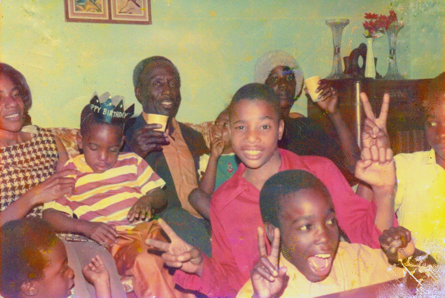 The Warnock family, pictured in 1974, celebrates the birthday of cousin Michael, seated on Verlene Warnock's lap. Future Senator Warnock, bottom left corner, attempts to imitate his older brother's pose while his father Jonathan, seated center, smiles at the camera (Courtesy of Senator Raphael Warnock)