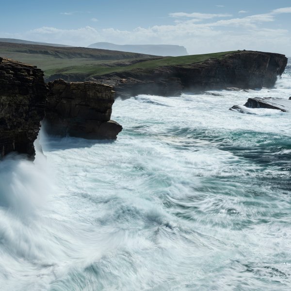 Waves crash against the cliffs of the Orkney Islands, whose unique geography have made it a global hub for tidal power