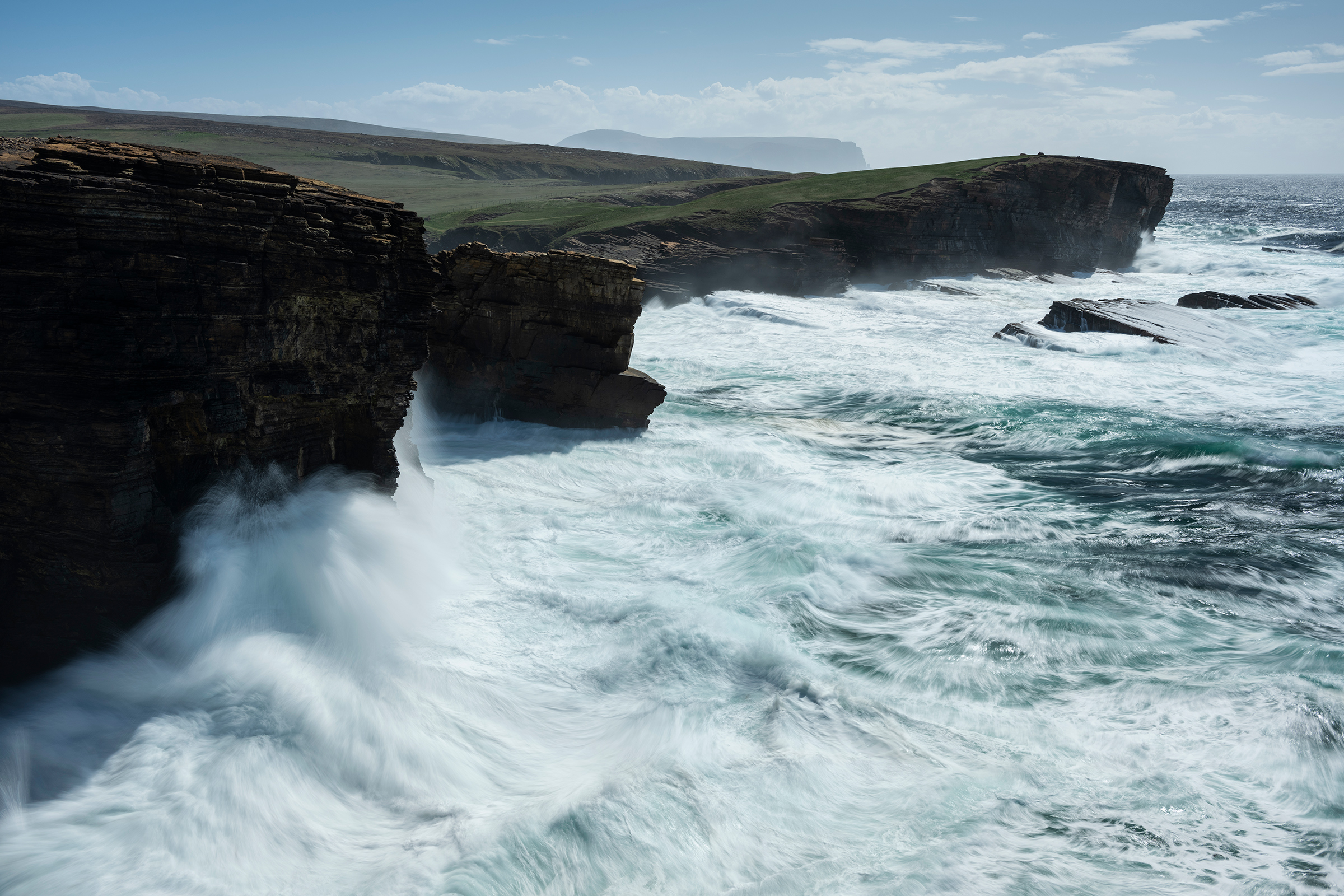 Waves crash against the cliffs of the Orkney Islands, whose unique geography have made it a global hub for tidal power (Cody Duncan—Getty Images)