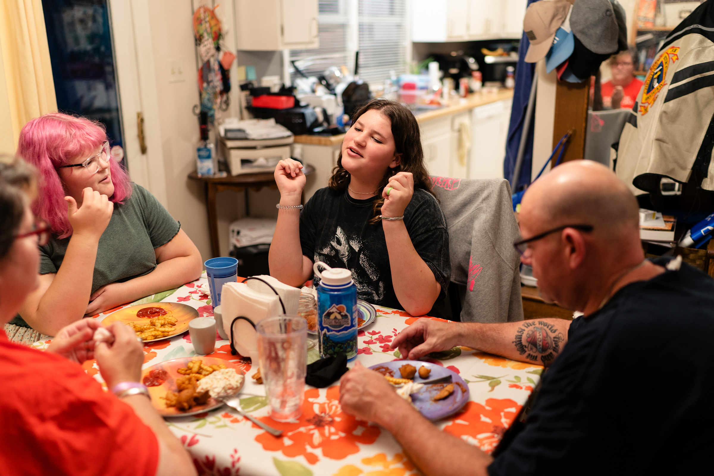 Maddie, 15, right center, eats dinner with her family in North Carolina. “My family is my whole life,” Maddie says. Whenever they have to make a decision, she says, they always consider how it will impact all four of them. “I love that for us,” she says. “All the times I’m with my family, whether we’re fighting or whether we’re laughing, it’s always good times.”