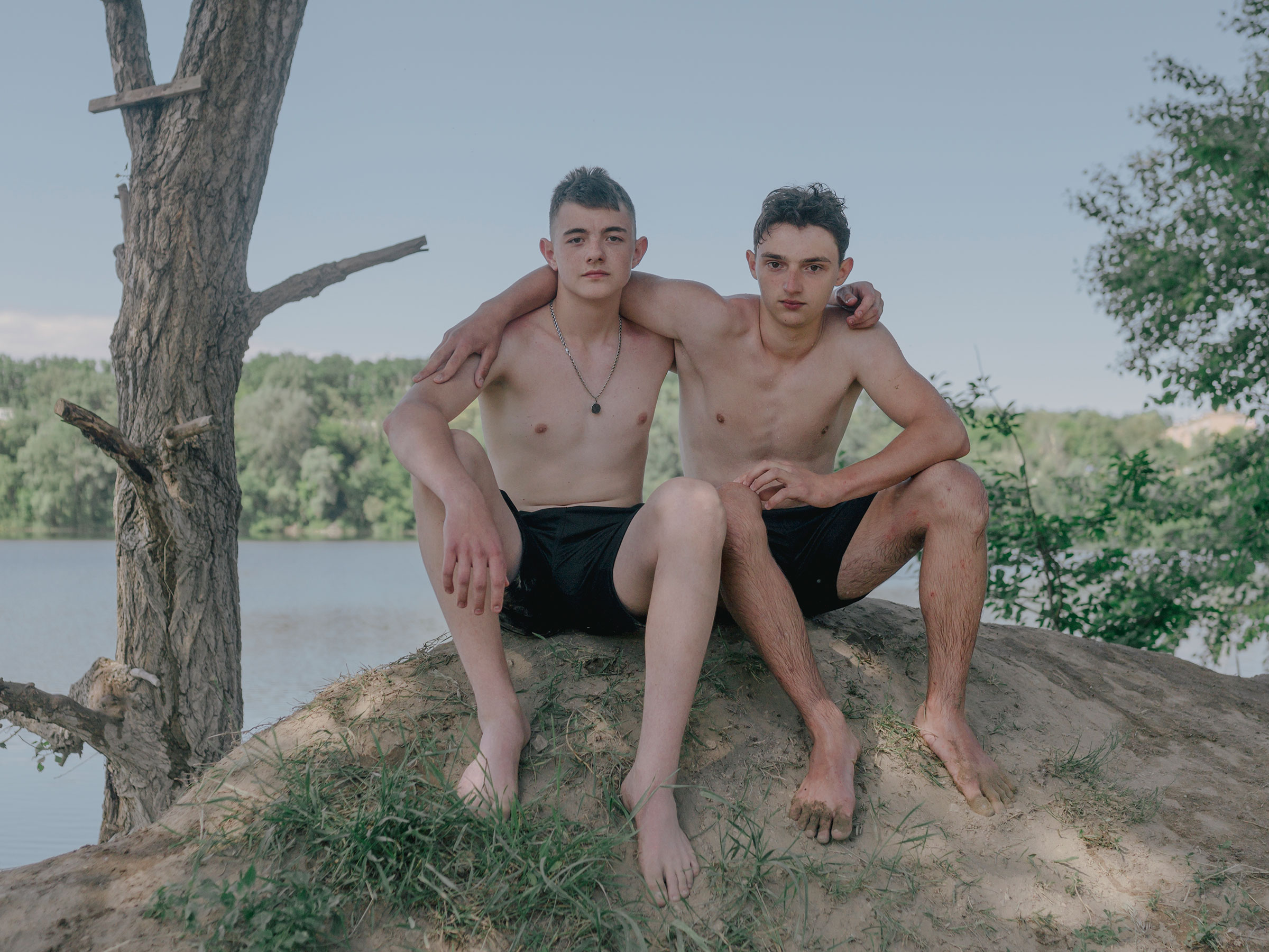 Close friends Grisha and Borys pose for a portrait at a lake. Within hours of leaving his home in Irpin, Grisha's street was taken over by Russian soldiers. (Fabian Ritter—DOCKS Collective)
