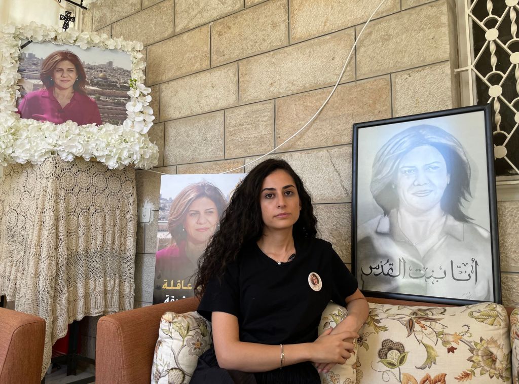 Lina Abu Akleh, the niece of slain Al Jazeera journalist Shireen Abu Akleh, sits surrounded by photographs of her late aunt, at the family home in occupied east Jerusalem, on July 13, 2022. (Rosie Scammell—AFP via Getty Images)