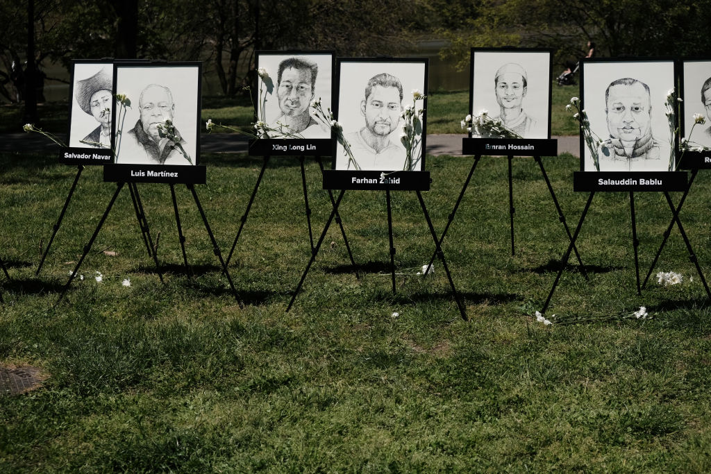 Portraits of deceased app based workers are displayed as delivery workers and rideshare drivers join with the group Justice for App Workers to honor app workers who were killed last year on May 10, 2022 in New York City. The workers held the event, A Memorial for Delivery Workers Killed on the Job, at the tree of peace in Inwood Hill Park in Manhattan. Workers across the country who work for companies such as Uber, Lyft, DoorDash and others have experienced high rates of death due to Covid, violence on the job and suicides. (Spencer Platt-Getty Images)