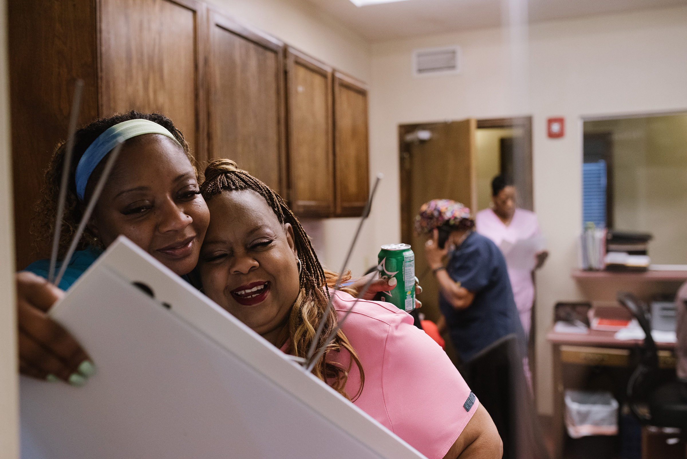 Medical assistant Ramona Wallace, left, embraces Gail Latham on July 11.