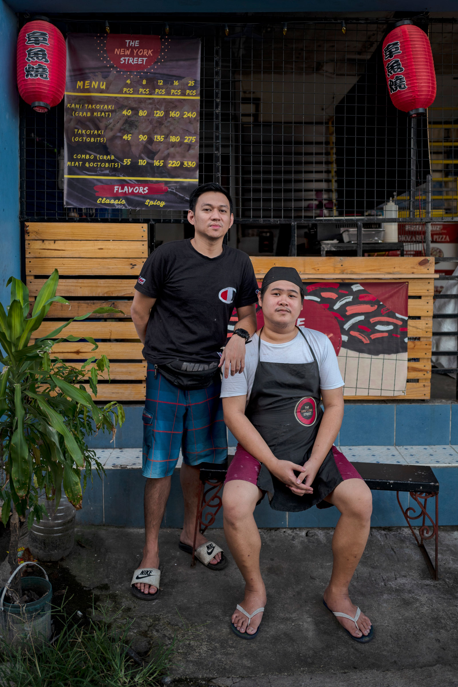 Orias (right) and his childhood friend Jonathan Artates at their Takoyaki shop in San Mateo, Rizal, in the outskirts of Manila, Philippines, on July 19, 2022. It was Artates who introduce Orias to the Axie Infinity game. He has also quit the game after his account was . (Ezra Acayan for TIME)