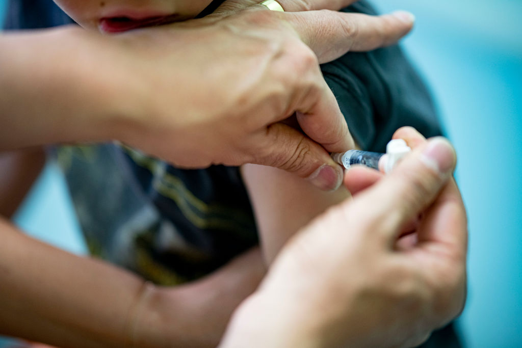 07 June 2021, Berlin: A pediatrician administers a booster of a dtp combination vaccine to a boy. (Fabian Sommer–DPA/Getty Images)